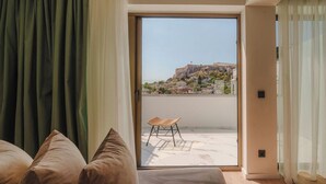 A room with a large sliding glass door leading to an outdoor terrace with a view of a historic building. - Eternity Athens (Athens)