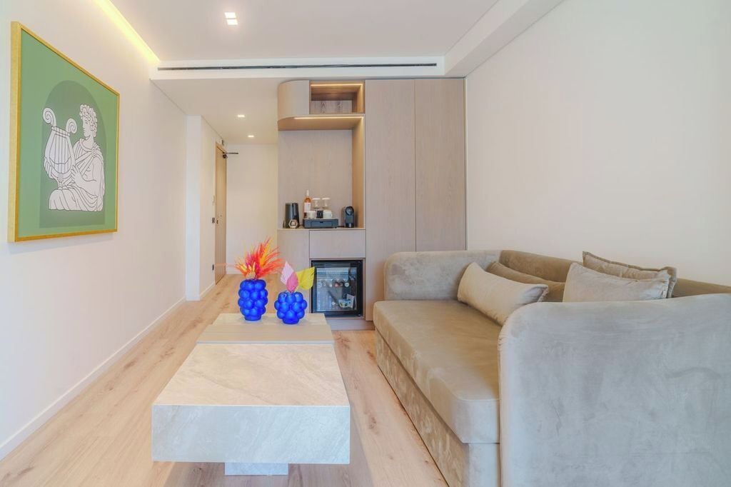 A modern living room with a beige sofa, a coffee table, and a framed artwork on the wall.