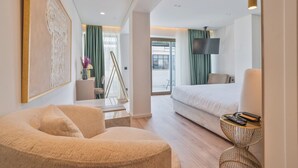A modern hotel room with a bed, a sofa, a TV, and a large window. - Eternity Athens (Athens)