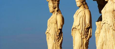 Une structure architecturale de style classique, ornée de trois statues.