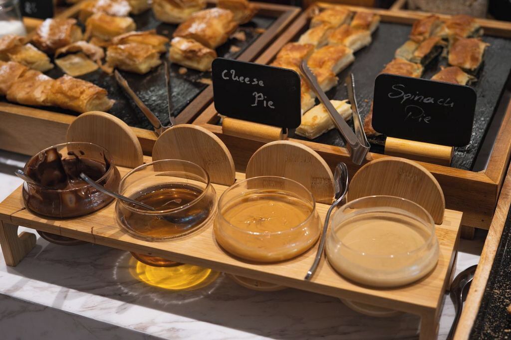 A dessert display with various pies and sauces.