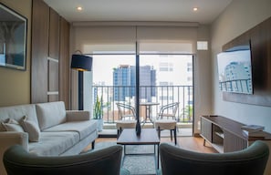 A modern living room with a sofa, chairs, a coffee table, and a TV on a wall. - w* | Amazing 2BR w/ Fantastic Pool in Miraflores (Miraflores)