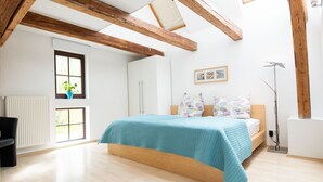 Een slaapkamer met een bed, bureau en radiator.