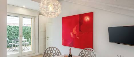 A dining area with a round table, two chairs, a bottle of champagne, and two glasses.