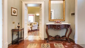A hallway with a mirror, a console table, and a patterned rug.