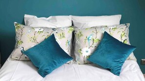 A bed with white bedding and two teal pillows against a teal wall. - 1. Les gîtes de Joséphine Gîte a Chateau de la loire (Courbouzon)