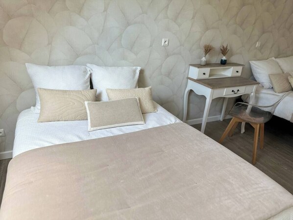 Un dormitorio con cama, mesitas de noche y una silla.