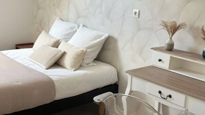 Une chambre à coucher avec un lit, une table de chevet et une chaise en plastique transparent.
