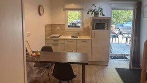 Une cuisine compacte avec un coin repas, un four à micro-ondes et une fenêtre.