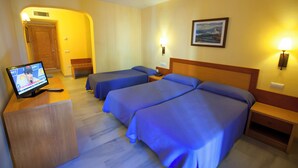A hotel room with two beds, a TV on a wooden desk, and a painting on the wall. - Hotel Olas de Almuñécar (Almuñécar)