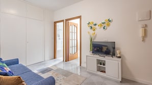 A living room with a sofa, TV, and decorative items. - Bijoux in the Centre of Sanremo by Wonderful Italy (Sanremo)