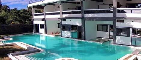 A modern multi-story building with a swimming pool.