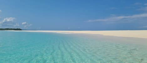 Una playa cerca, sillas reclinables de playa, toallas de playa