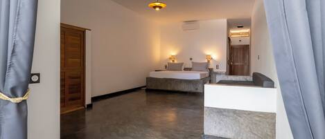 A modern hotel room with a large bed, bedside tables, and a ceiling light.