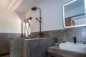 Ein Badezimmer mit Dusche, Waschbecken und Spiegel.