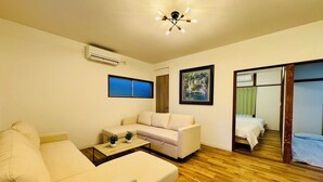 A modern living room with a sofa, a coffee table, and a bed with a wooden frame.