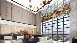 A spacious lobby with a large window offering a city view, a modern reception desk, and a seating area. - Jinmao Grandee Hotel Jiangyin Chengfa (Wuxi)