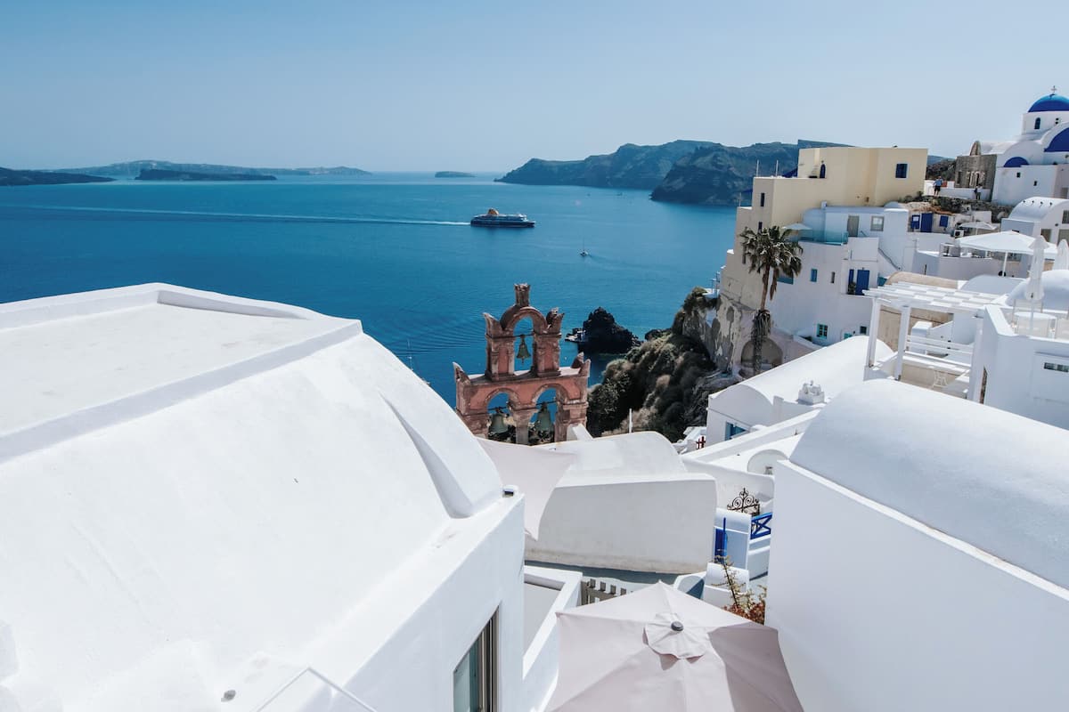 A white-walled building with a pool and a view of the sea.