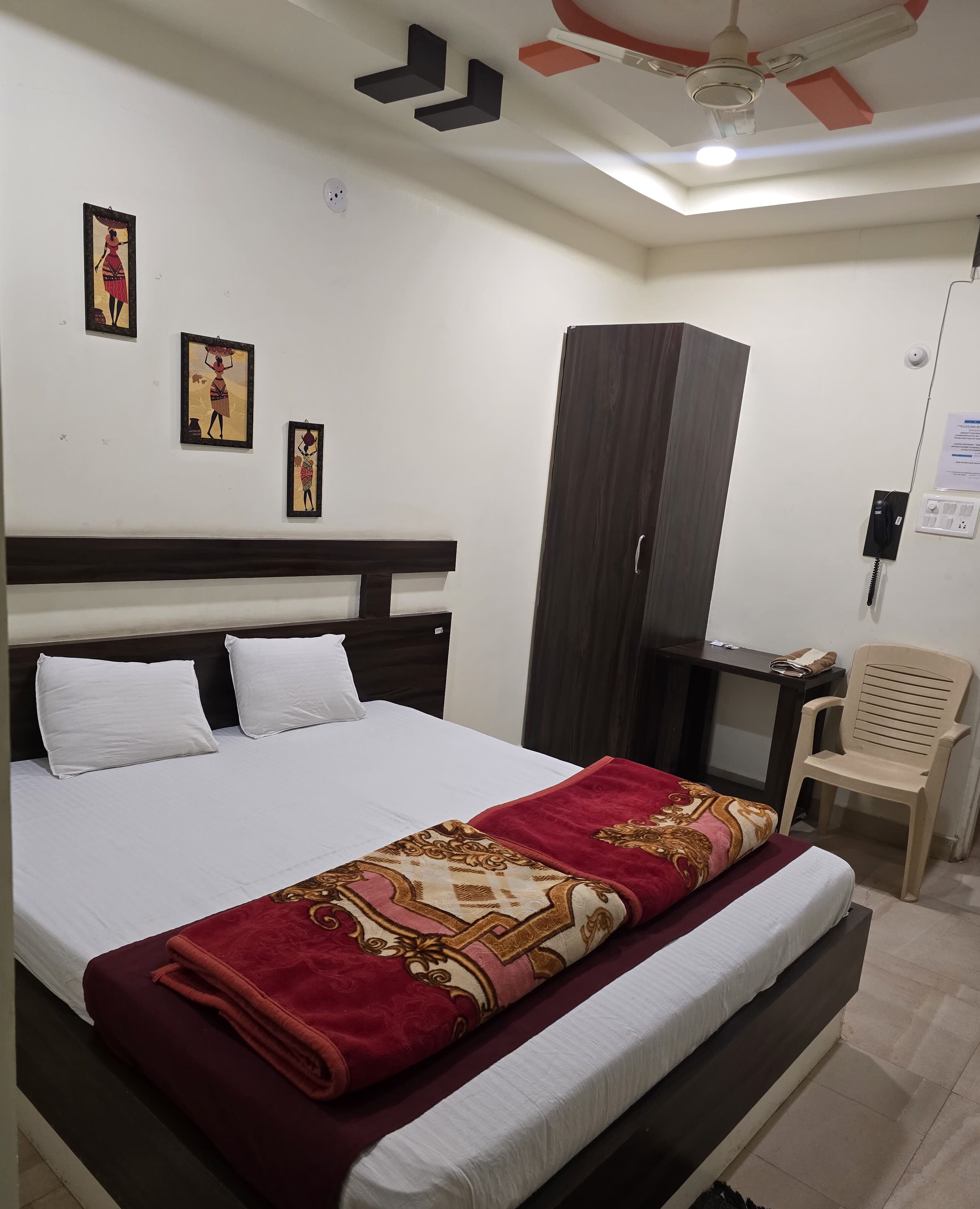 Una habitación de hotel con una cama, un escritorio, una silla y un armario.