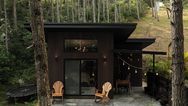 A modern house with a patio, two rocking chairs, and a trampoline. - Cozy Hideaway in the Mountains of Altos de María (Sorá)