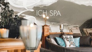 Een knus interieur met een bank, kussens, een decoratieve schaal en een muurschildering.