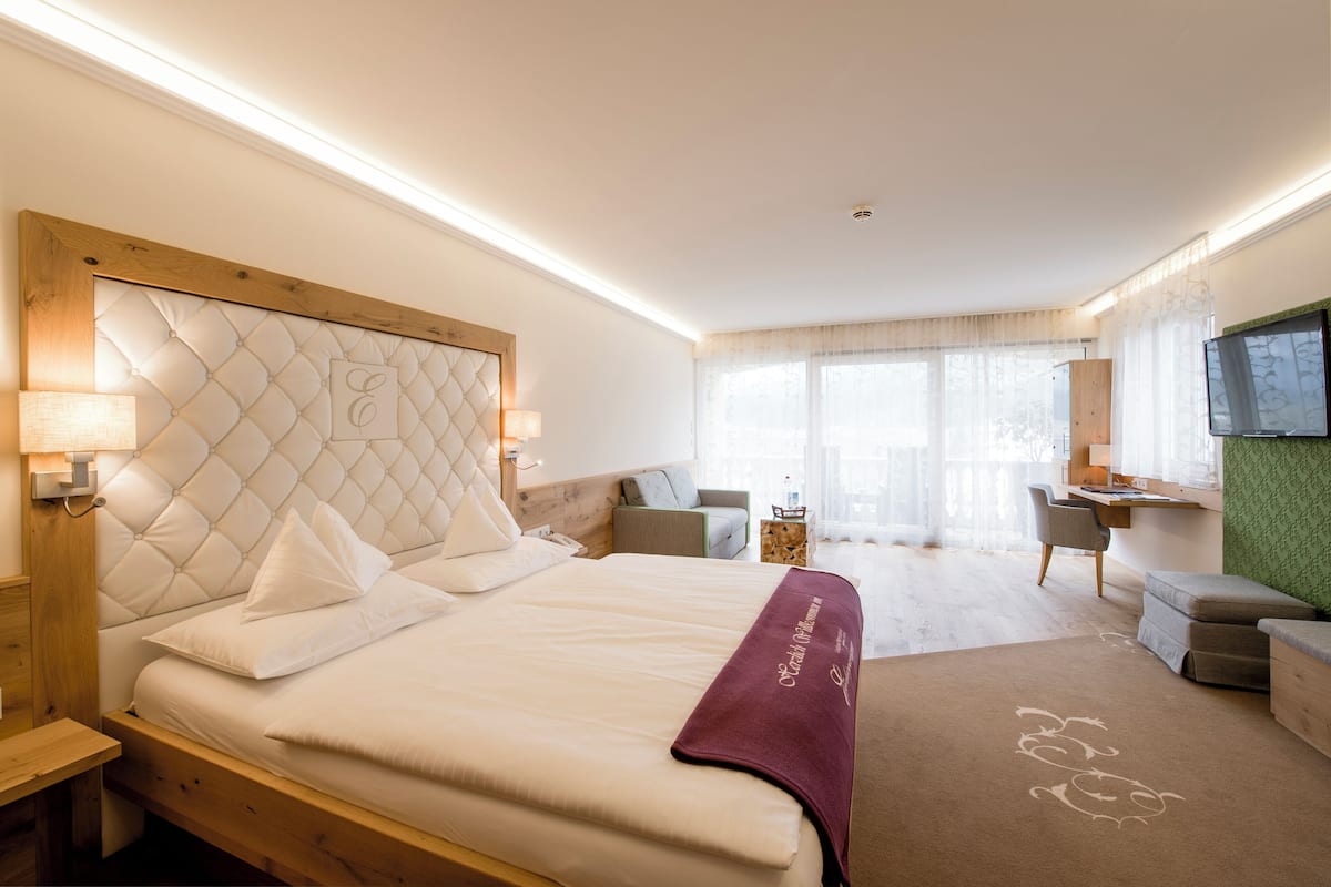 Een hotelkamer met een groot bed, een bureau, een stoel en een televisie.