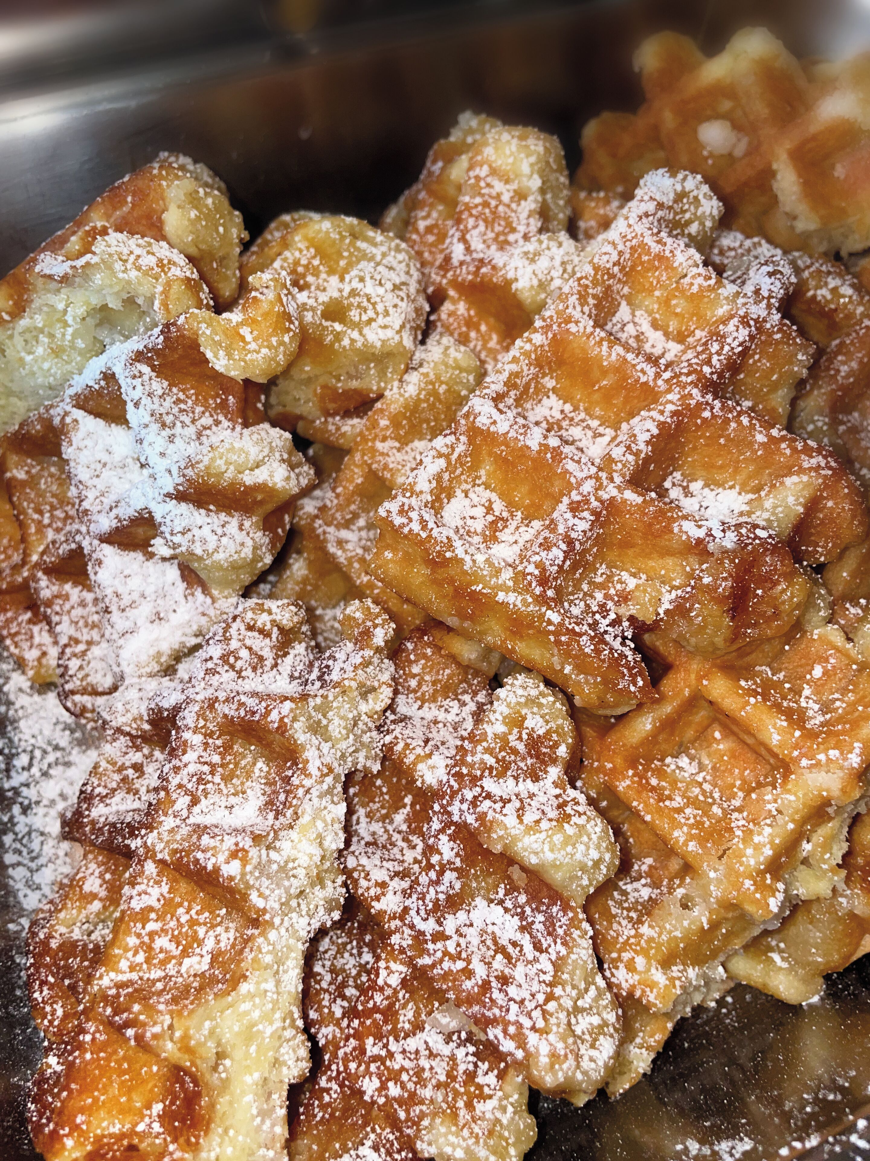 Un primo piano di waffle ricoperti di zucchero a velo.