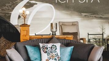 A cozy living area with a grey sofa, decorative pillows, and a wooden side table.