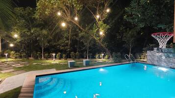Relax by the pool surrounded by lush greenery and enjoy a game of basketball.