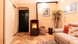 A cozy living room with a fireplace, a sofa, a rug, and a framed picture on the wall. - Beautiful private villa for 4 people with WIFI (Cervo)