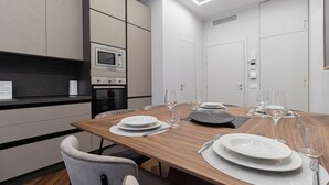 A modern kitchen with a dining area set for a meal. -  Italianway - XXV Aprile 7 B - Smeraldo (Milan)