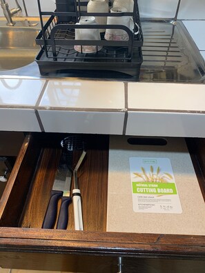 A kitchen counter with a cutting board and a knife.