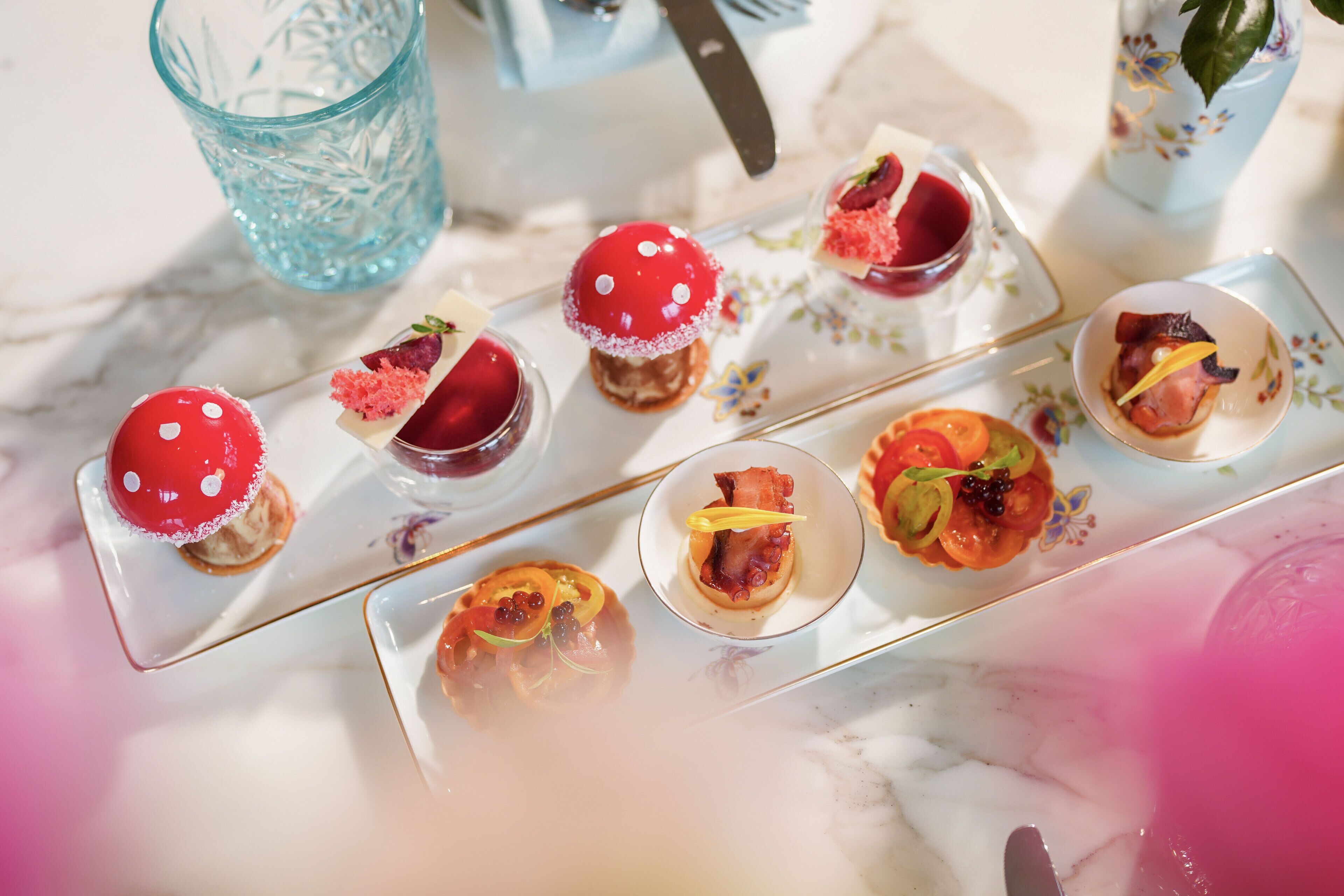 Une table où l’on trouve une variété de petits plats, dont certains sont garnis d’une sauce rouge et d’autres d’une garniture jaune.