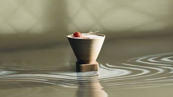 A ceramic cup with a dessert on a reflective surface.