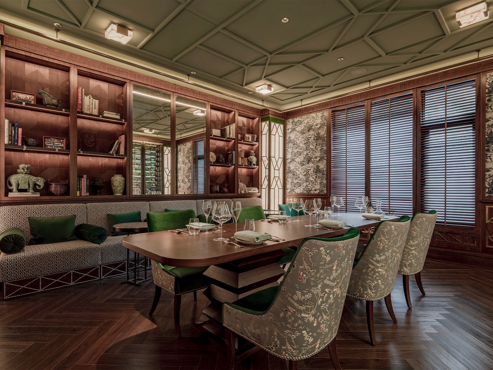 Een eetgedeelte met een houten tafel, gedekt voor vier personen, omringd door groene fauteuils.