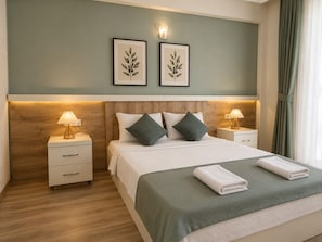 A neatly arranged hotel room with a bed, two bedside tables with lamps, a wooden headboard, and two framed botanical prints on the wall. - Tenedos İskele Otel (Ezine)