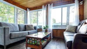 A cozy living room with a grey sofa, a brown leather chair, and a wooden coffee table with board games.