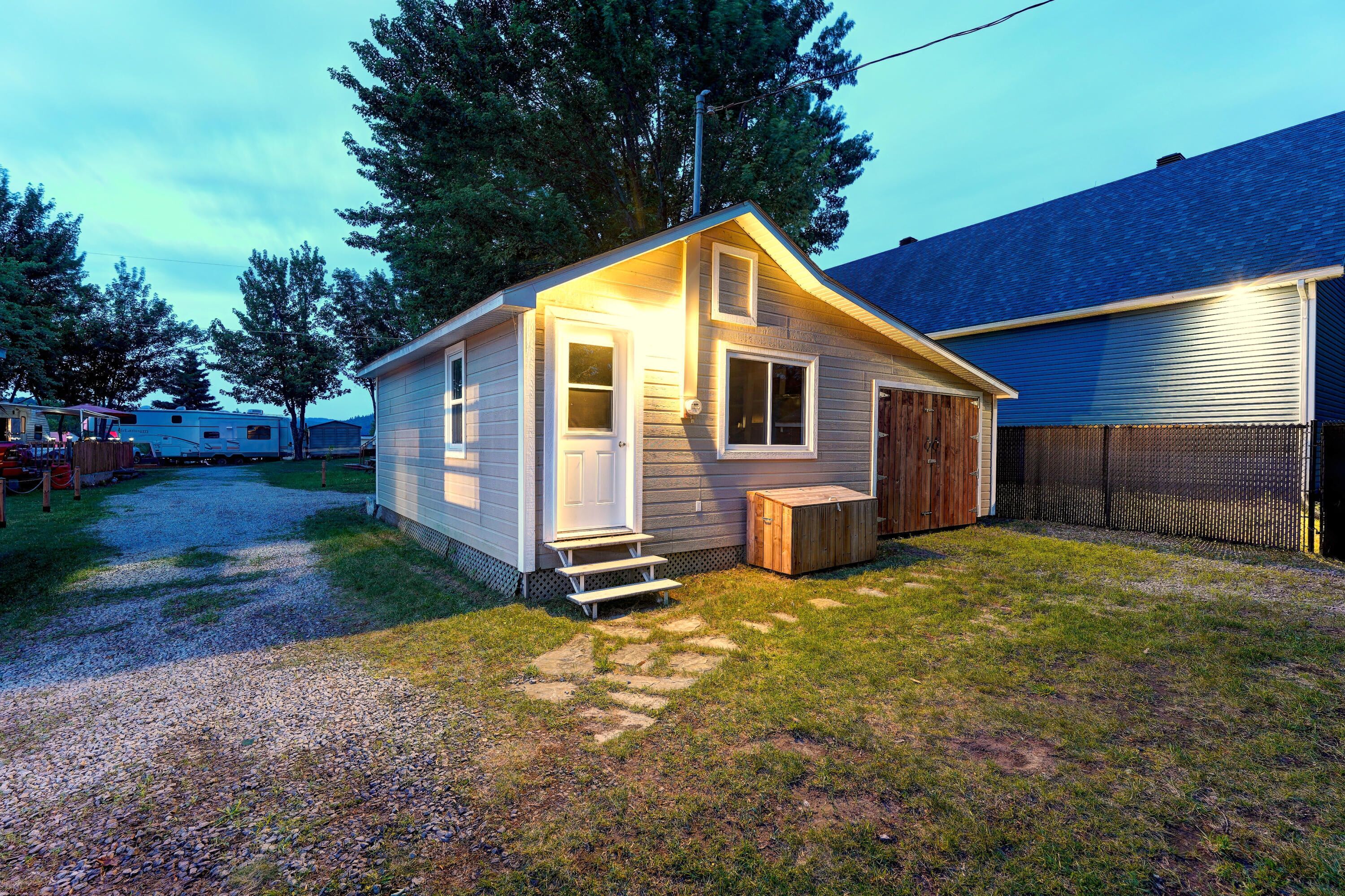 A small, single-story house with a front porch and a wooden deck.