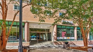A building with a sign reading "PEACHTREE TOWERS" and a FedEx logo on the window. - Downtown Hidden Gem w/ Balcony & Free Parking (Atlanta)