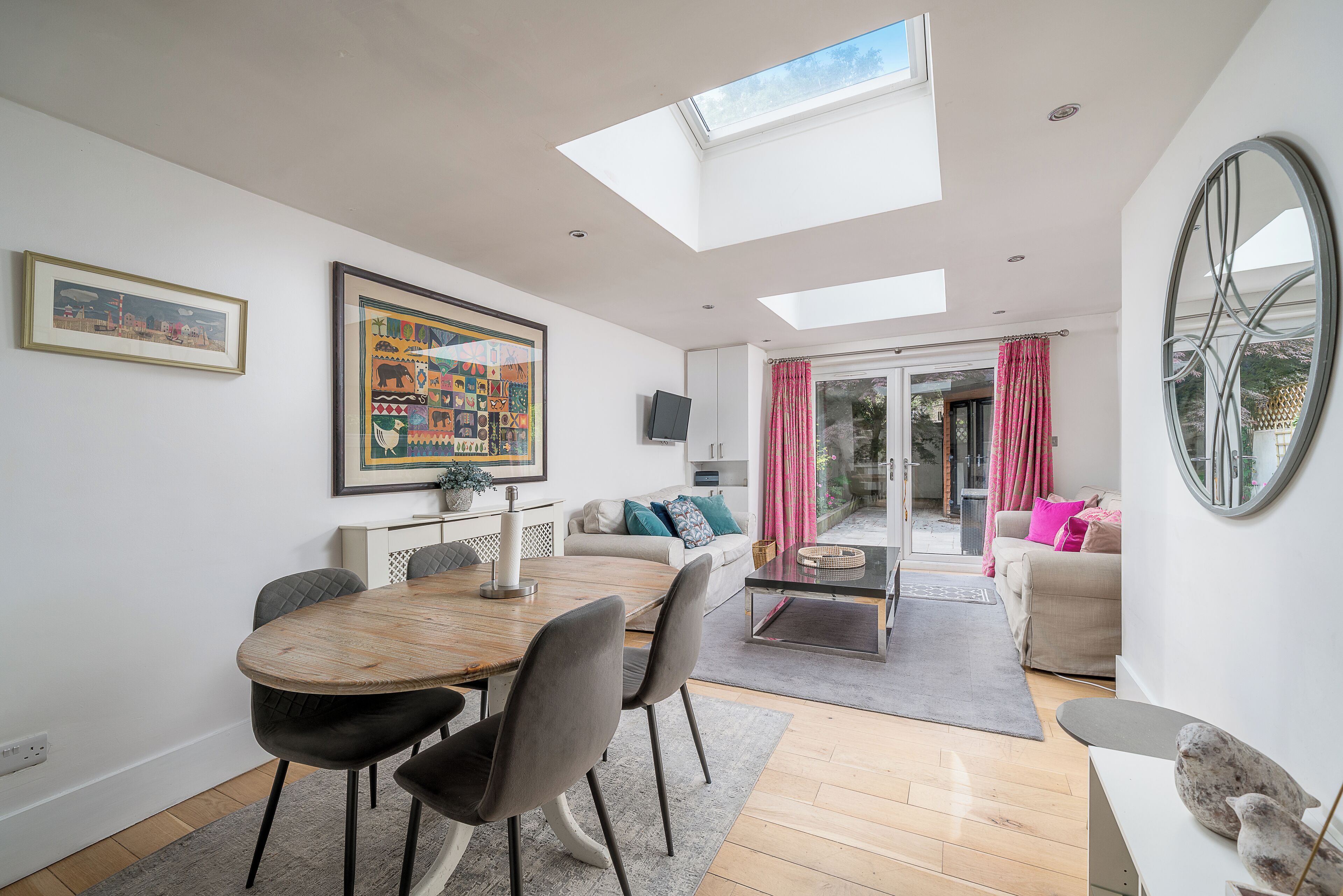 Una sala de estar moderna con comedor, ventanas amplias y vistas al exterior.
