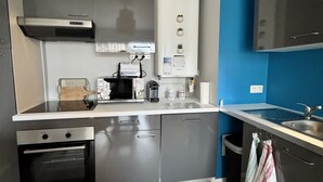 Una cocina moderna con horno empotrado, microondas y cafetera.