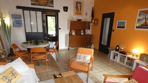 Una sala de estar acogedora con un sofá, sillones, una mesa de centro y una zona de comedor con mesa y sillas.
