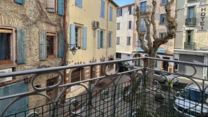 A narrow street with buildings featuring blue shutters and a tree in the foreground. - Renovated apartment 4 pers. in central Banyuls-sur-Mer (Banyuls-sur-Mer)