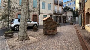 A narrow street with stone buildings, a parked car, and a small stone structure. - Renovated apartment 4 pers. in central Banyuls-sur-Mer (Banyuls-sur-Mer)