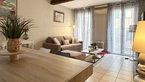 A living room with a sofa, a coffee table, a lamp, and a plant. - Renovated apartment 4 pers. in central Banyuls-sur-Mer (Banyuls-sur-Mer)