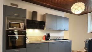A modern kitchen with grey cabinets, a built-in microwave, a coffee maker, and a sink. - Renovated apartment 4 pers. in central Banyuls-sur-Mer (Banyuls-sur-Mer)