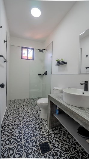 Un baño con ducha, inodoro y lavamanos.