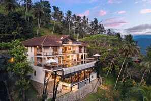 A multi-story house with a balcony, surrounded by lush greenery and palm trees. - Taru Villas Levita - Kandy (Kandy)