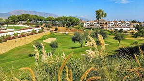 A golf course with a hotel in the background. - Modern 3 bed garden apt next to pool Casa Banderas (La Cala de Mijas)