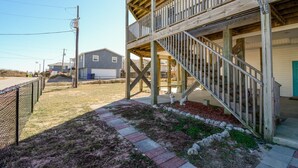Ein zweistöckiges Holzhaus mit einem Balkon und einer Treppe, die zu der oberen Etage führt.